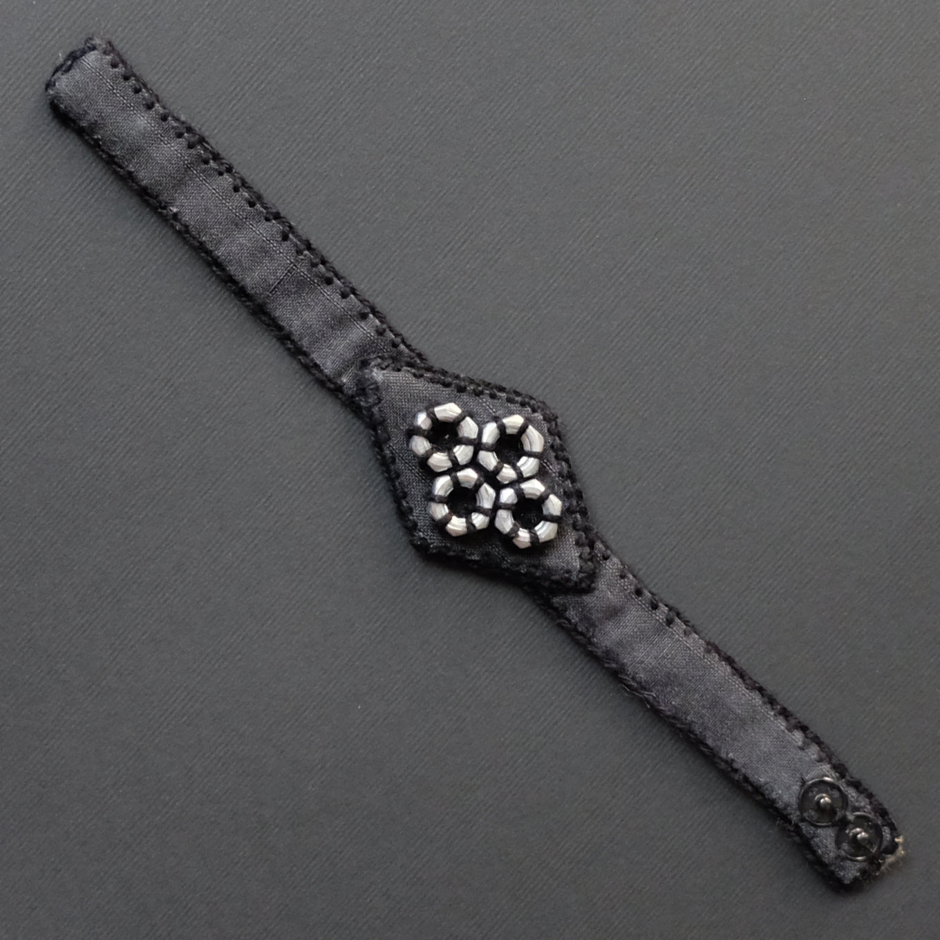 Bracciale a rombo in seta rivalorizzata e bulloni.